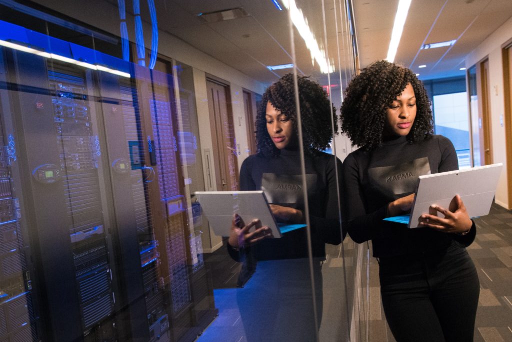 woman holding laptop beside glass wall 1181316